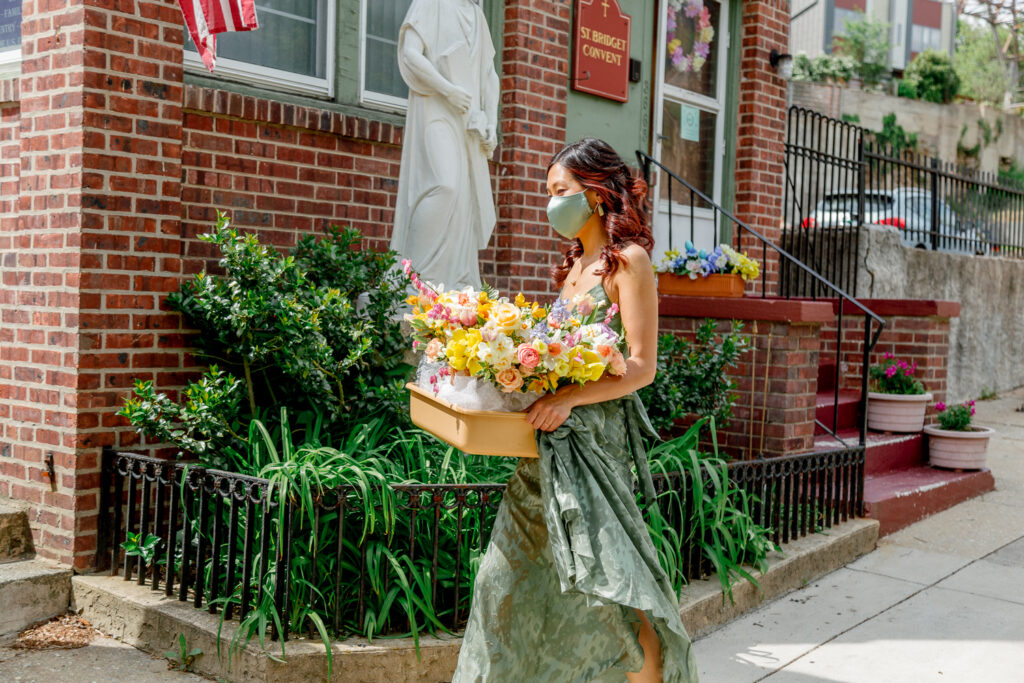 Bridesmaid bringing colorful spring wedding bouquets into the church in East Falls