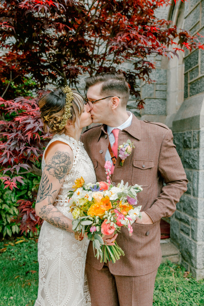 Newlyweds kissing outside the church by Philadelphia wedding photographer Vay Photo