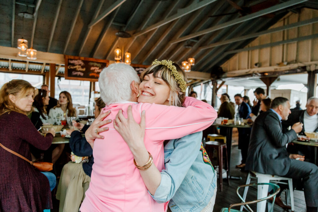 Bride hugging her grandmother at a small waterfront wedding reception in Pennsylvania