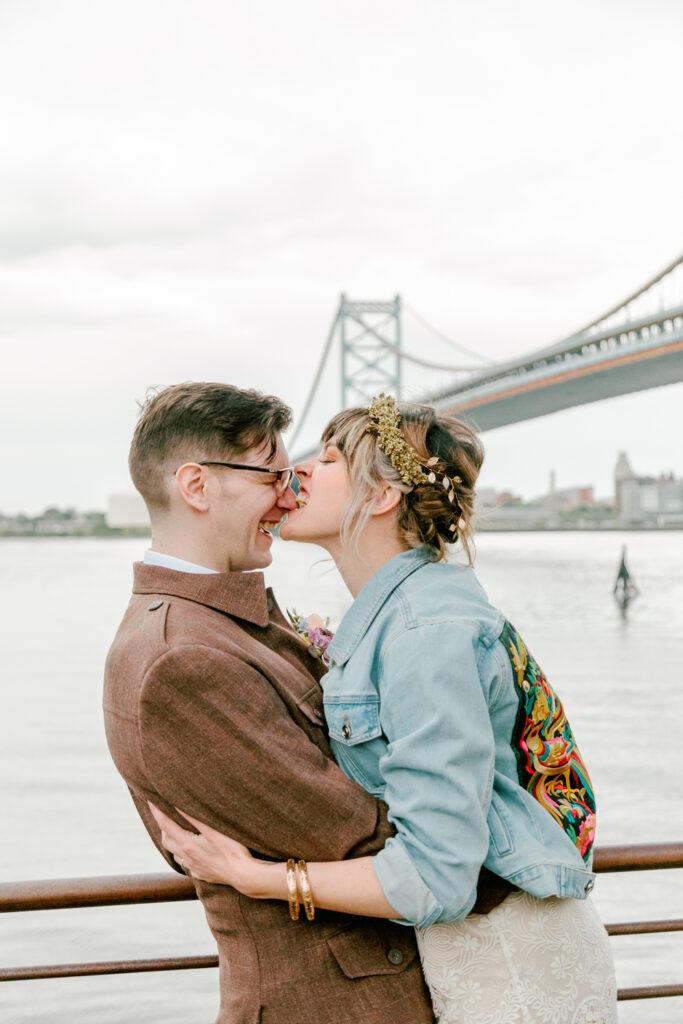 Bride biting the groom's nose on the Philadelphia waterfront by wedding photographer Vay Photo