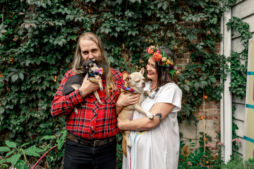 Bride and groom with their dogs before an intimate backyard wedding ceremony