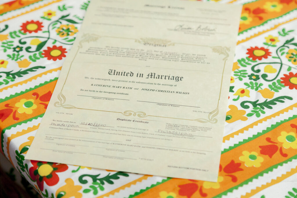 Marriage certificate on top of a vibrant tablecloth for a casual backyard wedding