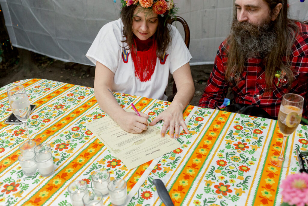 Bride signing the marriage license during an intimate backyard wedding celebration in Philadelphia