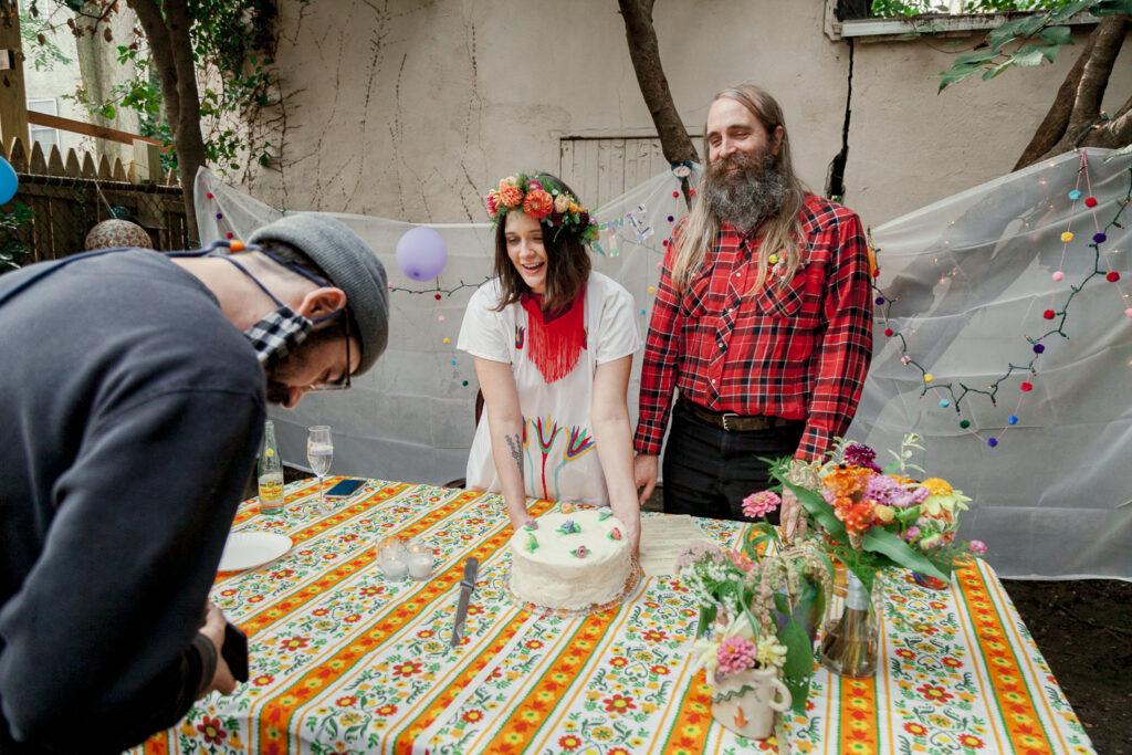 Bride and groom admiring their wedding cake during a backyard elopement by Philadelphia wedding photographer Vay Photo